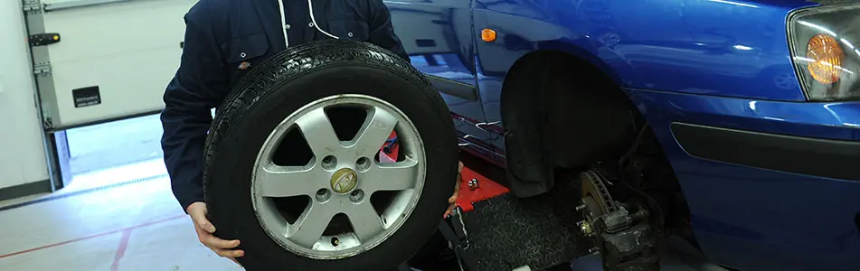 Car tyre being held by a student